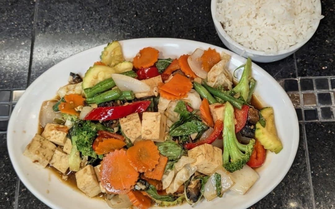 Vegetable Delight with tofu and mixed vegetables, served with a bowl of rice at Tasty Thai Tempe.